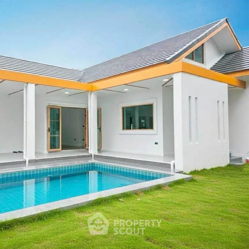 Modern house with private pool and lush green lawn, perfect for luxury living.