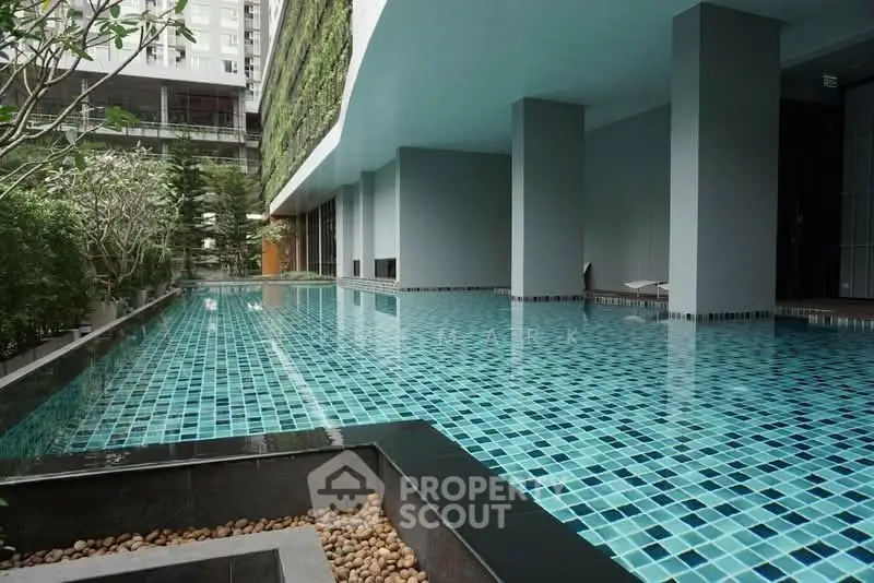 Luxurious modern building with stunning outdoor pool and lush greenery.