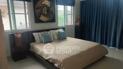 Spacious bedroom with modern decor and large windows for natural light.