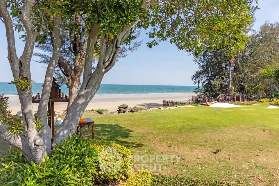 Stunning beachfront property with lush greenery and ocean views, perfect for luxury living or vacation retreat.