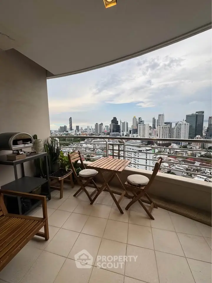Stunning city view from a modern balcony with stylish outdoor seating, perfect for relaxation and entertainment.