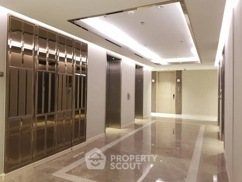 Luxurious modern elevator lobby with marble flooring and sleek design.