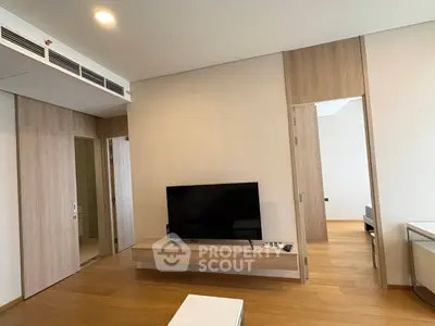 Modern living room with wooden flooring and sleek TV setup in a stylish apartment.