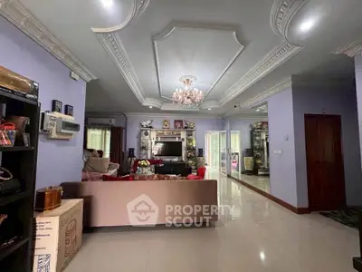 Elegant living room with chandelier and decorative ceiling, spacious and inviting for family gatherings.