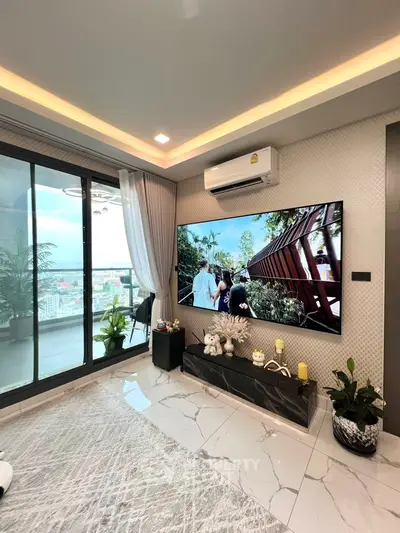 Modern living room with large TV and balcony view