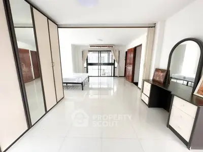 Spacious bedroom with large wardrobe and vanity in modern apartment