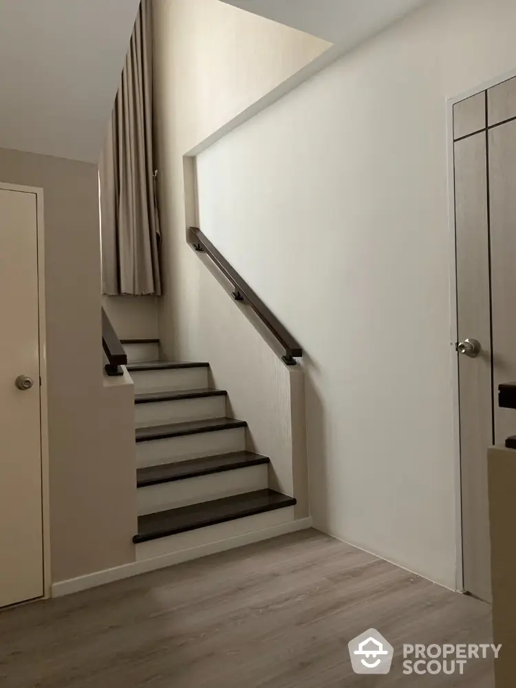 Modern staircase with sleek design and neutral tones in a contemporary home interior.