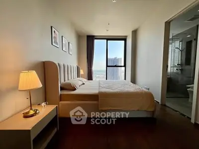 Spacious bedroom with modern decor and city view, featuring a cozy bed and elegant lighting.