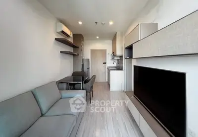 Modern living room with sleek furniture and open kitchen layout in a stylish apartment.