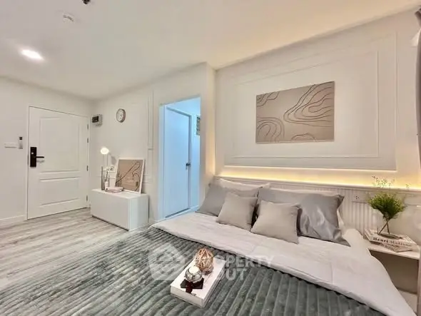 Modern bedroom with stylish decor and cozy ambiance, featuring elegant lighting and contemporary artwork.