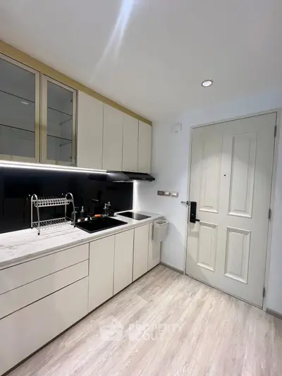 Modern kitchen with sleek cabinetry and marble countertop in a stylish apartment