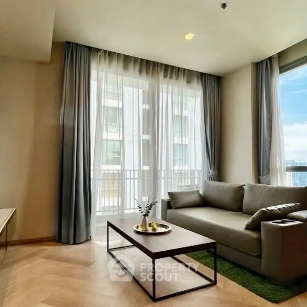 Modern living room with large windows and stylish furniture in a high-rise apartment.
