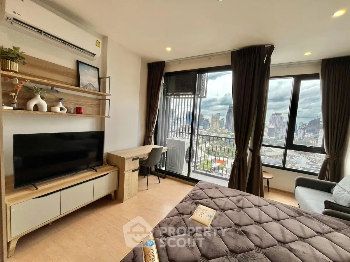 Modern studio apartment with city view, featuring cozy living area and large windows for natural light.