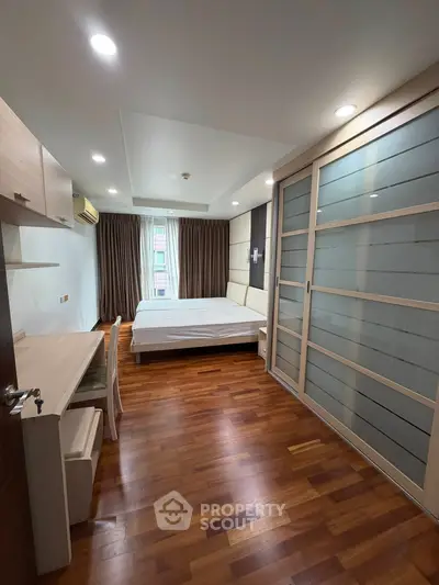 Modern bedroom with wooden flooring and sliding wardrobe doors