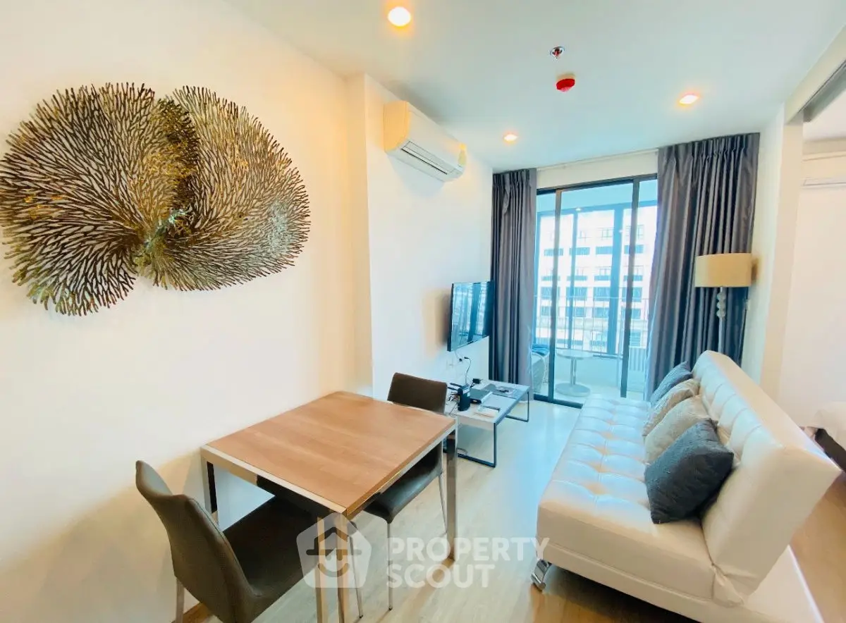 Modern living room with stylish decor and balcony view in a high-rise apartment.