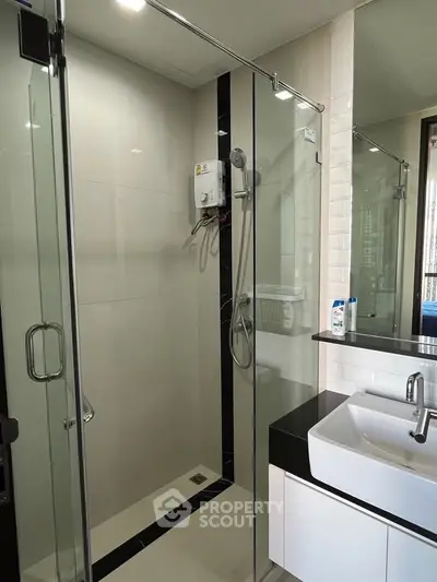 Modern bathroom with glass shower enclosure and sleek sink design