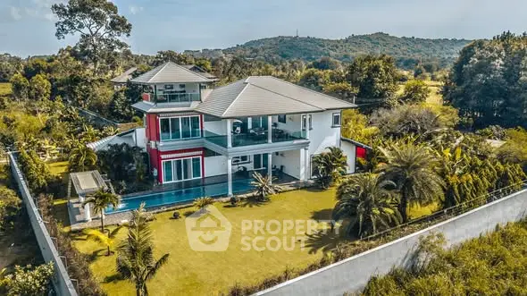 Luxurious modern villa with pool and lush garden in serene countryside setting.