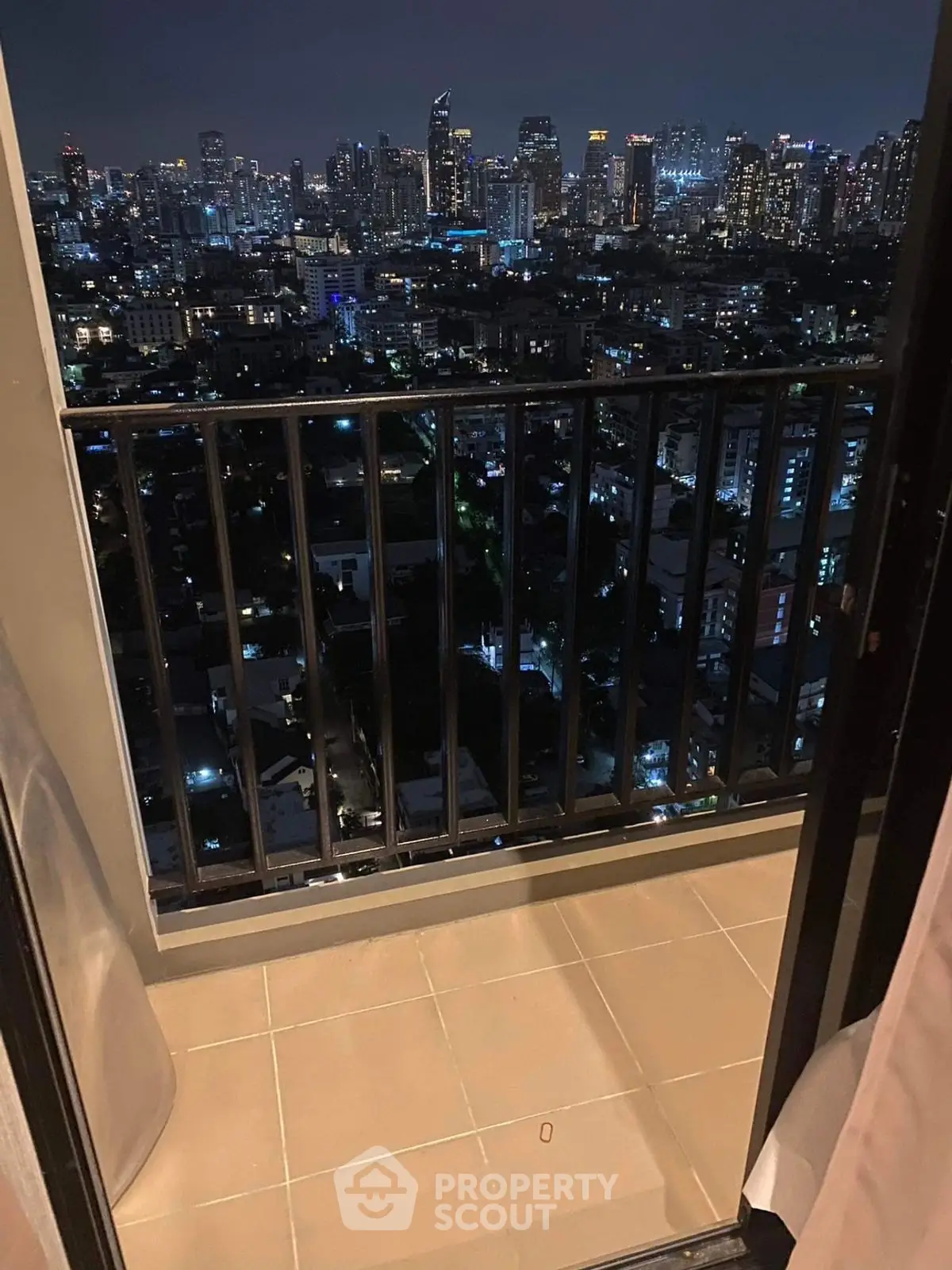 Stunning city skyline view from a high-rise balcony at night.