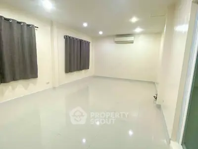 Spacious empty room with tiled flooring and air conditioning, ideal for customization.