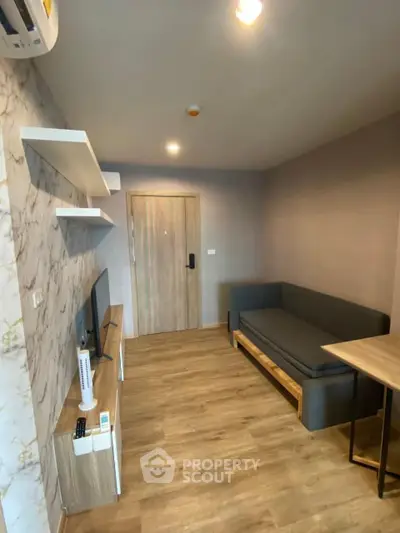 Modern living room with sleek furniture and wooden flooring in a stylish apartment.