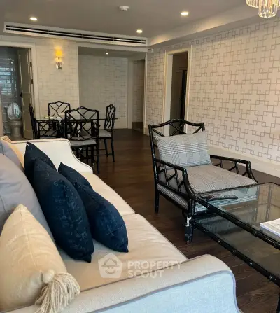 Spacious living room with elegant decor and dining area, featuring stylish furniture and modern lighting.