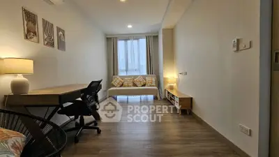 Modern study room with desk, chair, and cozy sofa in bright apartment.