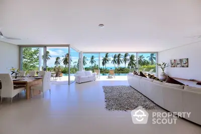 Luxurious open-plan living room with stunning ocean view and elegant decor.