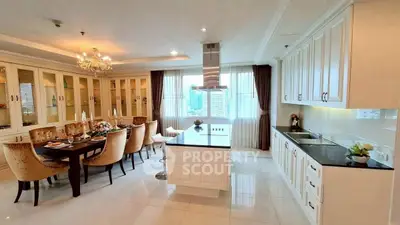 Luxurious open-layout kitchen and dining area with elegant chandelier and city view.