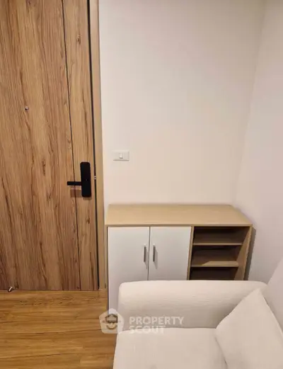 Modern interior with wooden door, sleek cabinet, and cozy sofa in a stylish living space.