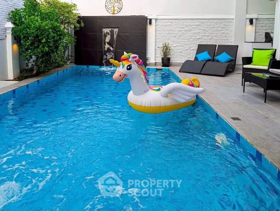 Luxurious private pool with unicorn float and stylish lounge chairs in modern outdoor setting.