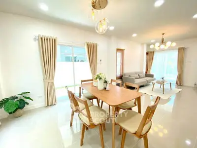 Spacious modern living and dining area with elegant lighting and natural light