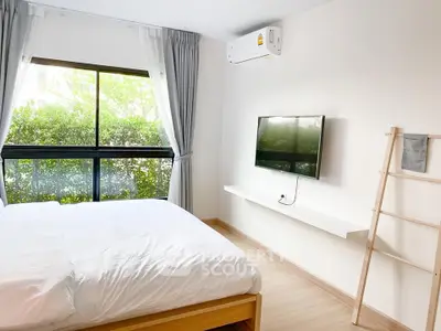 Bright bedroom with large window, modern TV setup, and minimalist decor.