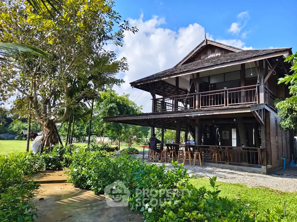 Charming wooden house with lush garden and spacious outdoor seating area.