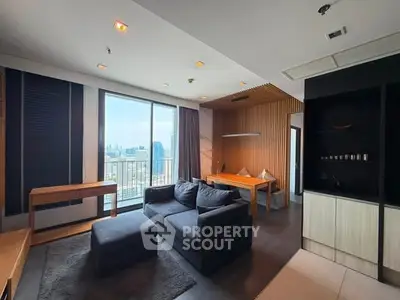 Modern living room with city view, featuring sleek furniture and stylish decor in a high-rise apartment.
