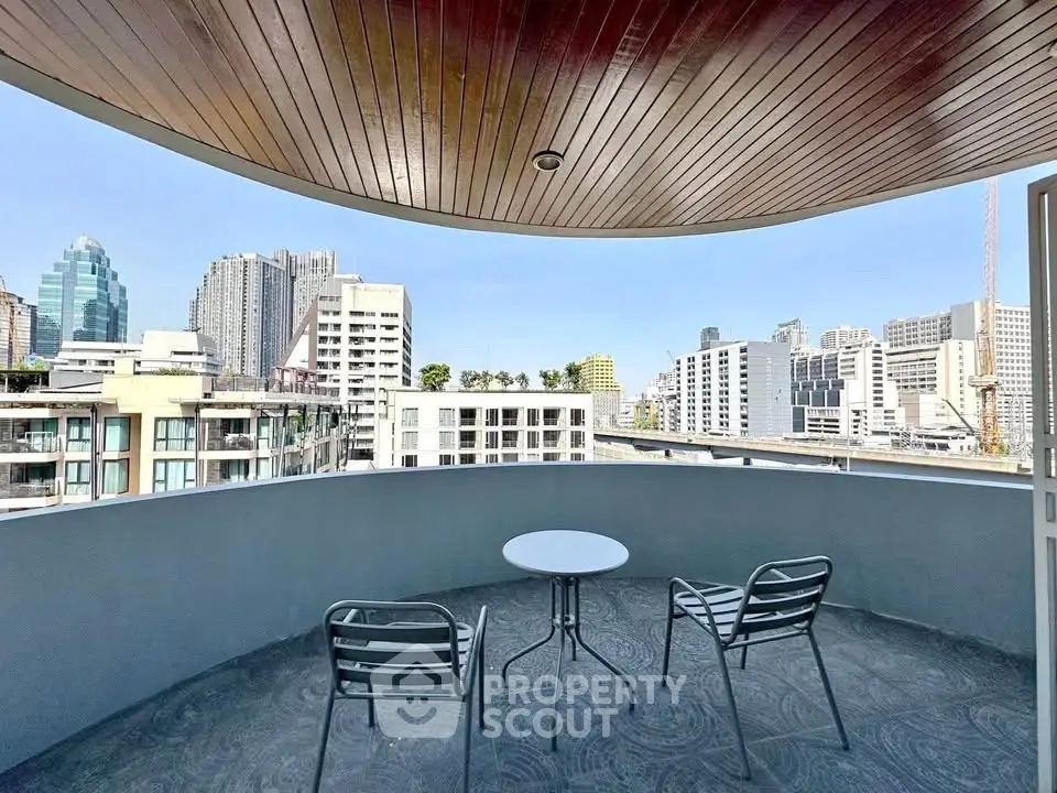 Spacious balcony with city skyline view, perfect for relaxation and enjoying urban living.