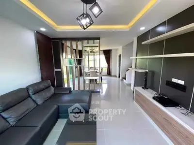 Modern living room with sleek design and open layout, featuring stylish furniture and ambient lighting.