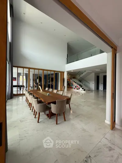 Spacious modern living room with high ceilings and elegant dining area, perfect for luxury living.