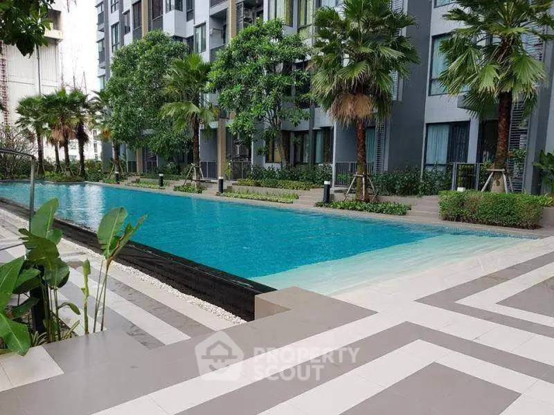 Luxurious apartment complex with a stunning outdoor pool and lush greenery.