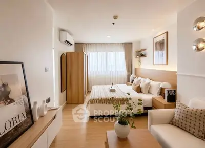 Modern bedroom with stylish decor and natural light, featuring cozy seating and elegant furnishings.