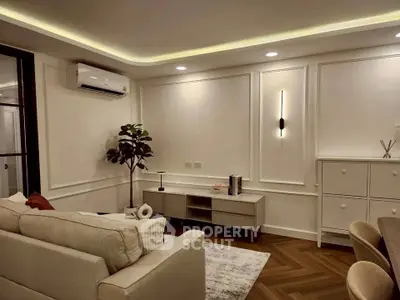 Elegant living room with modern decor and ambient lighting, featuring a cozy sofa and stylish wall accents.