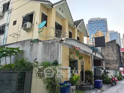 Charming urban house with lush greenery and city skyline backdrop, perfect blend of tranquility and convenience.