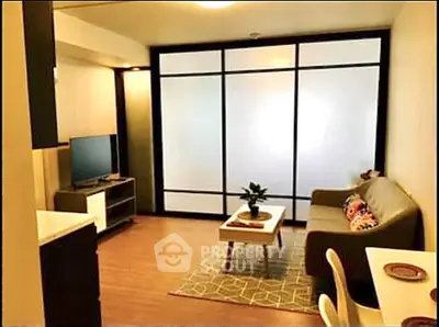 Modern living room with sleek design and frosted glass partition, featuring cozy seating and stylish decor.