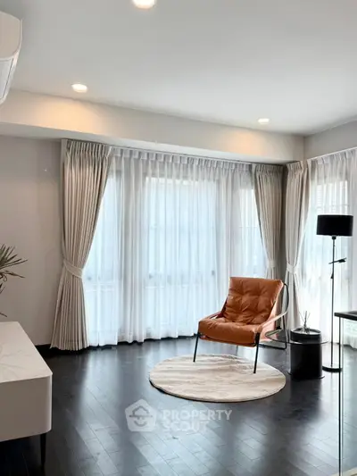 Elegant living room with stylish chair and floor-to-ceiling windows