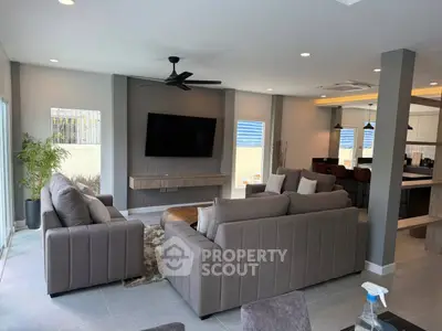 Spacious modern living room with elegant furniture and open kitchen layout.