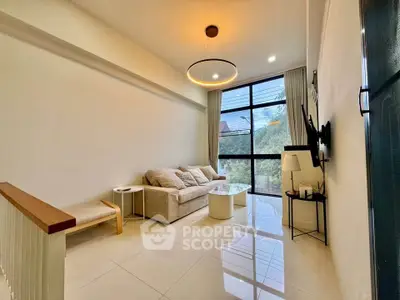 Modern living room with large window and stylish lighting in a cozy apartment.