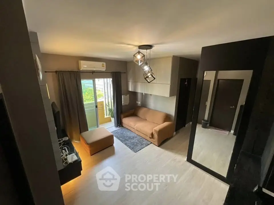 Modern living room with stylish decor and balcony access in a cozy apartment.