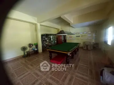 Spacious recreation room with billiard table and trophy display, perfect for entertainment.