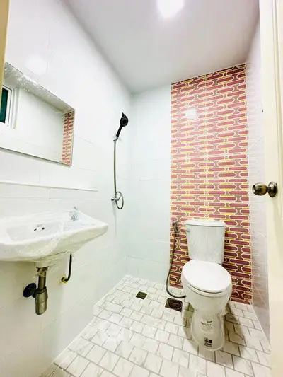Modern bathroom with unique brick-patterned accent wall and sleek fixtures.