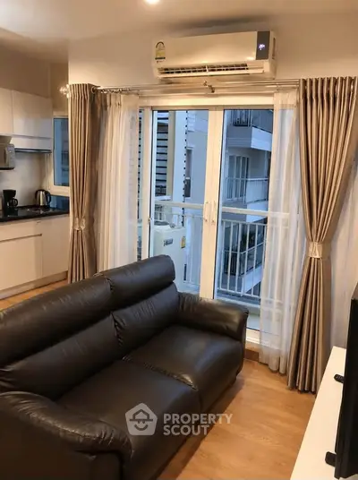 Modern living room with leather sofa and balcony view in a stylish apartment.