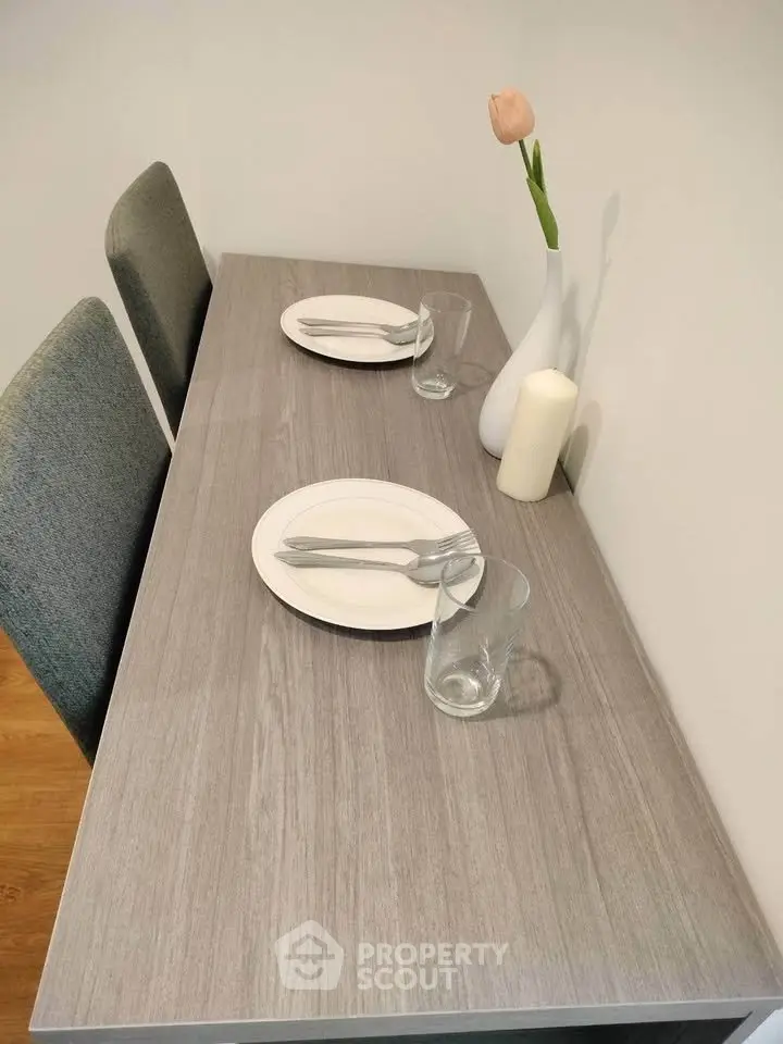 Modern dining area with sleek table setting and elegant decor in a cozy apartment.
